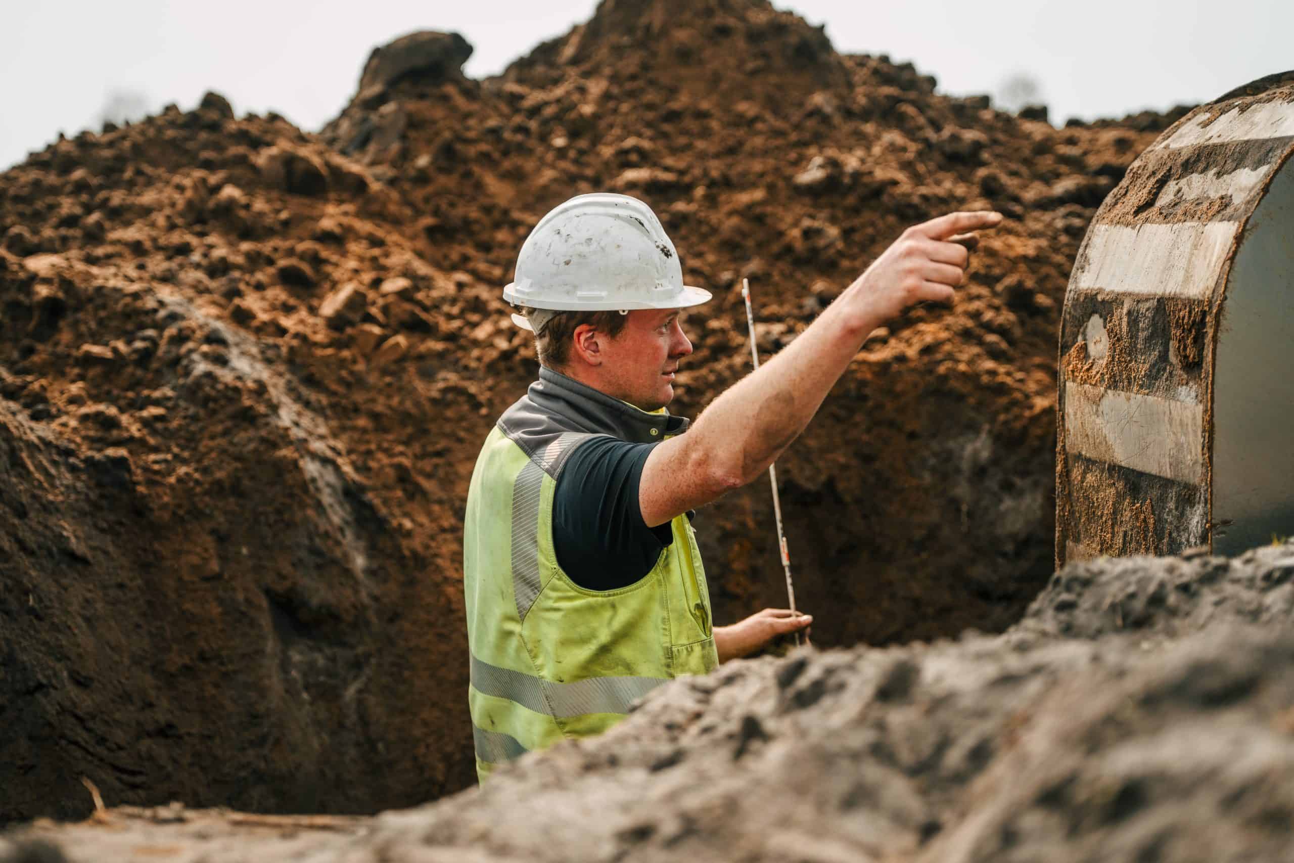 Bauarbeiter mit Schutzhelm auf einer Baustelle, Detailaufnahme.