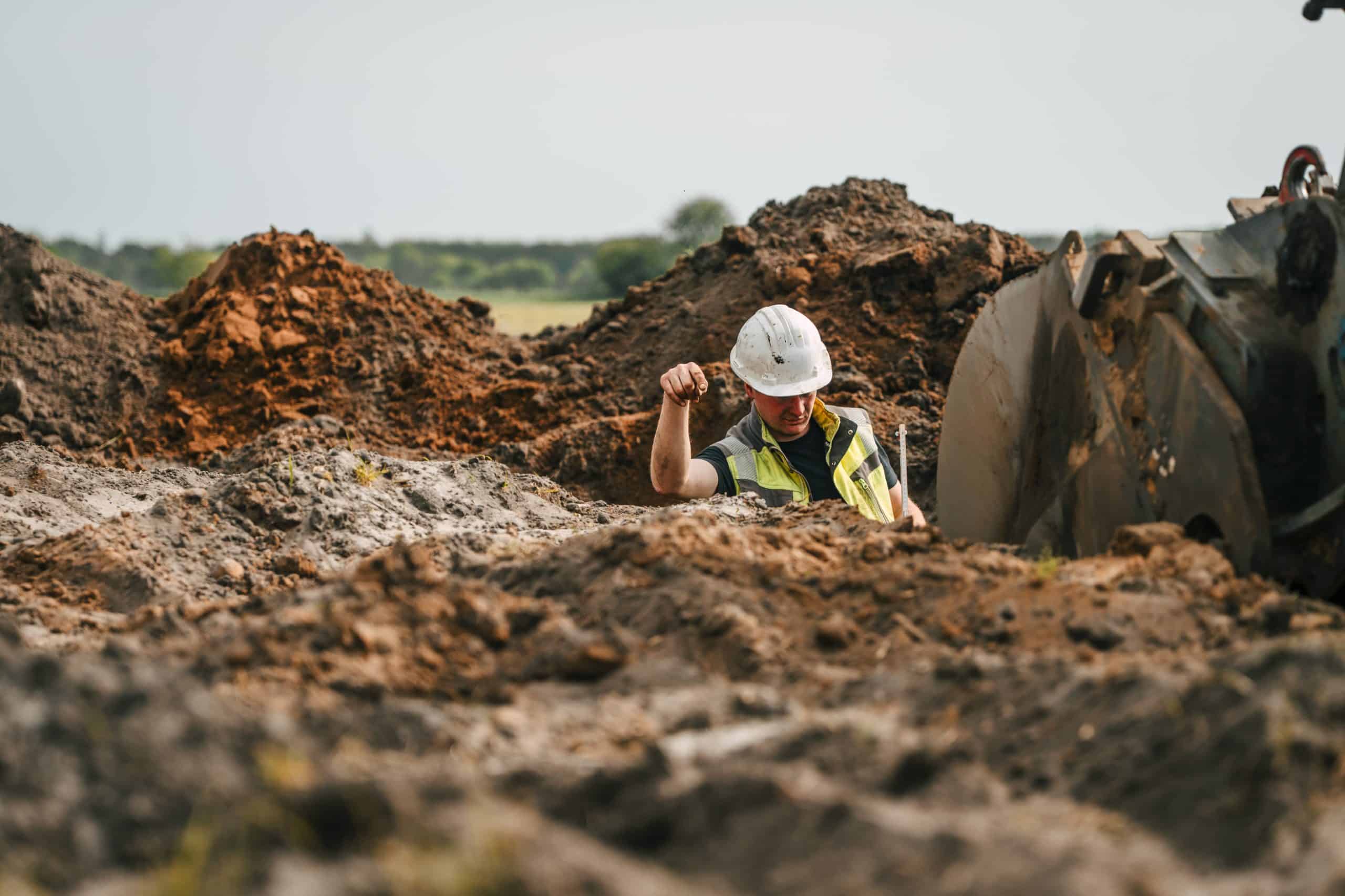 Grubenführer inspiziert Baugrund im Tagebau für nachhaltige Erdarbeiten und Rohstoffförderung.